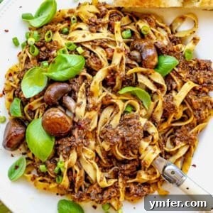 Rich Fungi Ragout 13 mushroom bolognese with a fork and fresh basil