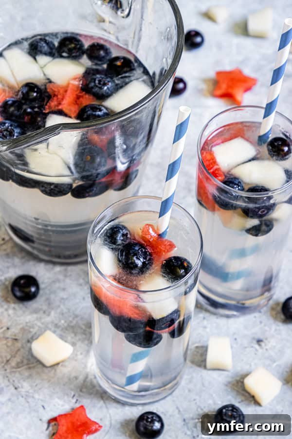 Nation's Nectar 2 Two glasses of Patriotic Lemonade with paper straws, garnished with star-shaped fruit.