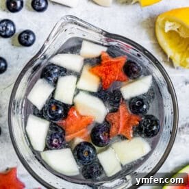 Nation's Nectar 6 Patriotic Lemonade in a glass pitcher, with fruit settled at the bottom.