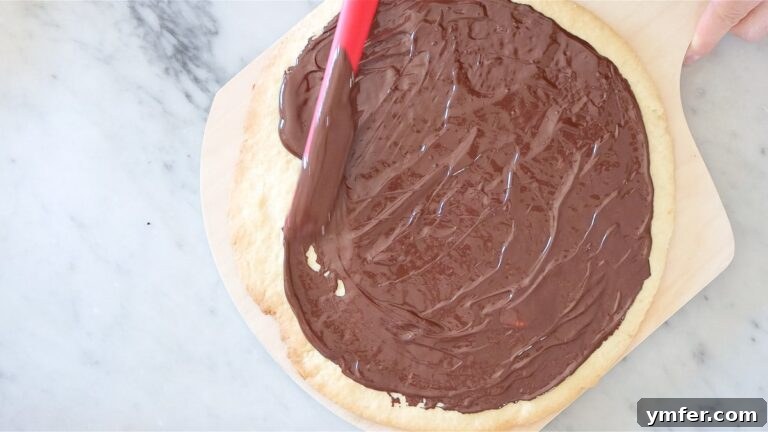 Rainbow Fruit Pizza 21 spreading the chocolate on the pie crust base