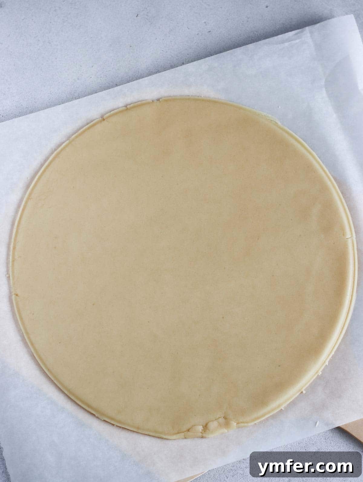 Rainbow Fruit Pizza 7 Sugar cookie dough expertly rolled into a perfectly round, thin disk on parchment paper, ready for baking.