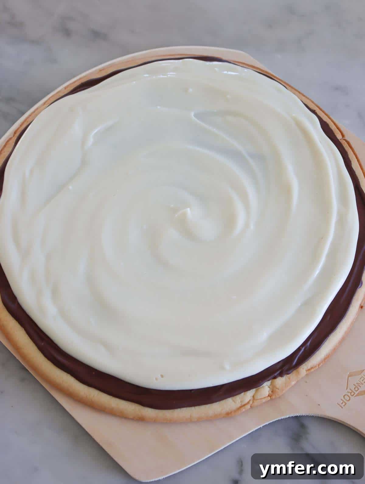 Rainbow Fruit Pizza 10 Smooth, creamy dairy-free cream cheese frosting generously spread over a hardened chocolate layer on a fruit pizza base.