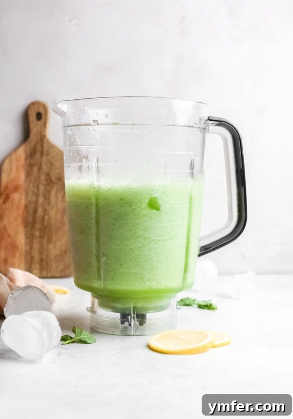 Limonana Frost 4 A glass pitcher filled with vibrant green frozen mint lemonade (Limonana), garnished with fresh mint leaves and lemon slices, ready to be served.