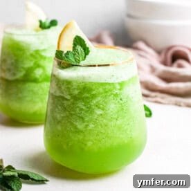 Limonana Frost 7 A glass of refreshing frozen mint lemonade with mint leaves and lemon slices.