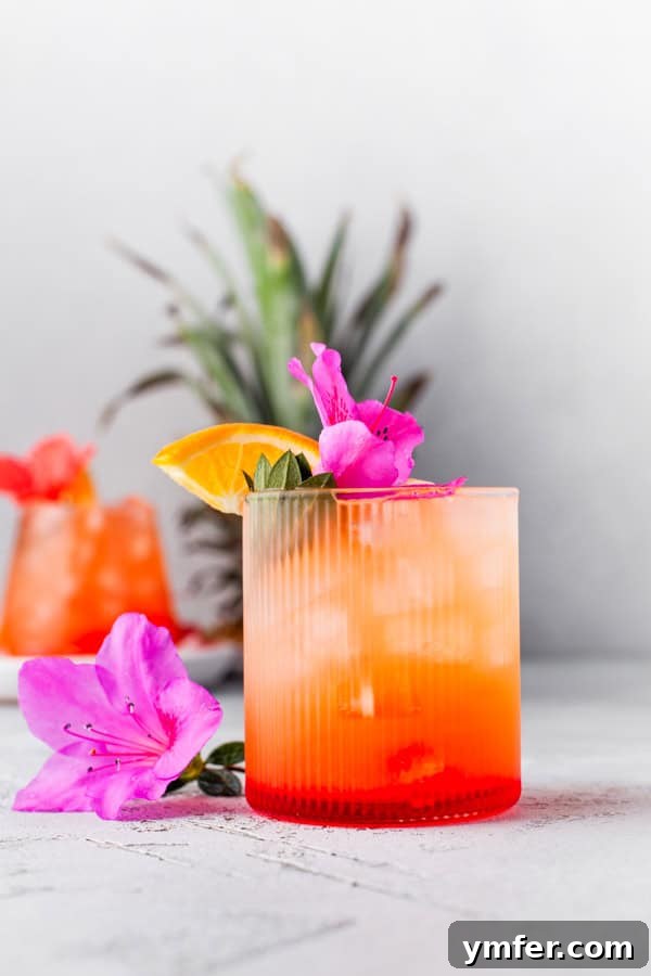 Tropical Rum Delight 2 Pineapple Rum Punch topped with an edible flower.