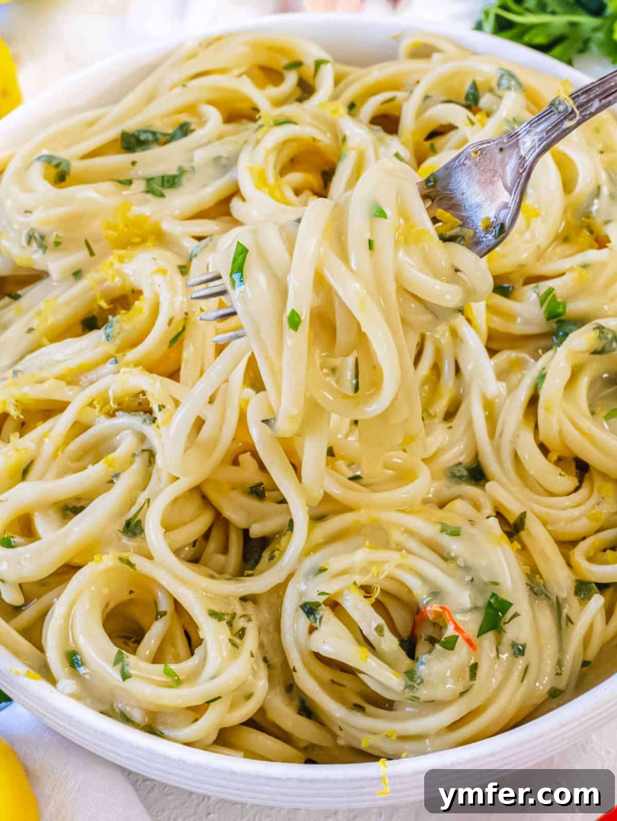Effortless Lemon Pasta (Creamless) 6 Close-up of a forkful of lemon pasta without cream, showing the creamy texture of the lemon garlic sauce clinging to the noodles.
