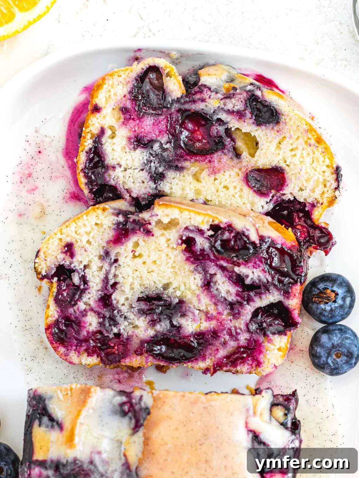 Lush Blueberry Pound Cake 2 Slices of moist blueberry pound cake bursting with jammy blueberries and topped with a lemon glaze.