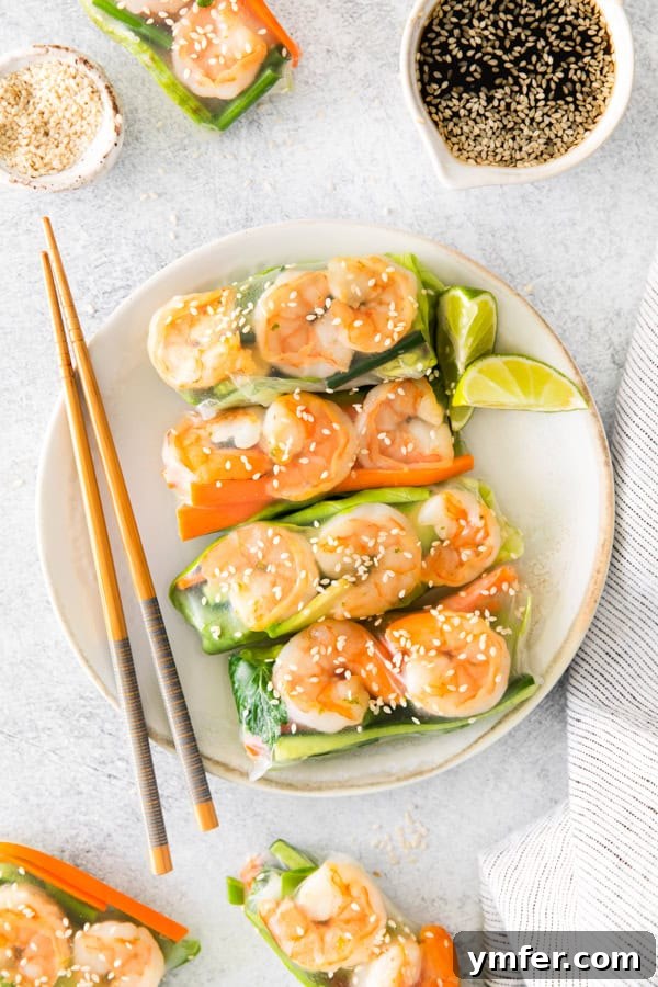 Refreshing Shrimp Garden Rolls 2 Freshly prepared Shrimp Summer Rolls artfully arranged on a white plate with elegant chopsticks, showcasing the vibrant ingredients and a bowl of ponzu sesame dipping sauce.