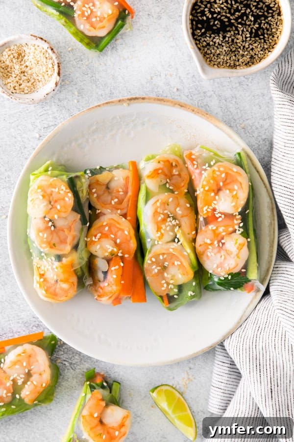 Refreshing Shrimp Garden Rolls 5 A cluster of perfectly rolled Shrimp Summer Rolls, showcasing their appealing translucency and vibrant fillings, neatly arranged on a plate.