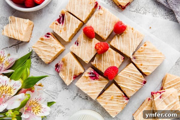 Ruby Raspberry Blondies 6 White chocolate raspberry blondies garnished with fresh raspberries and a white chocolate drizzle.