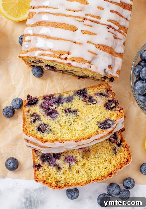 Bursting Blueberry Lemon Loaf 2 Blueberry Lemon Pound Cake sliced on parchment paper.