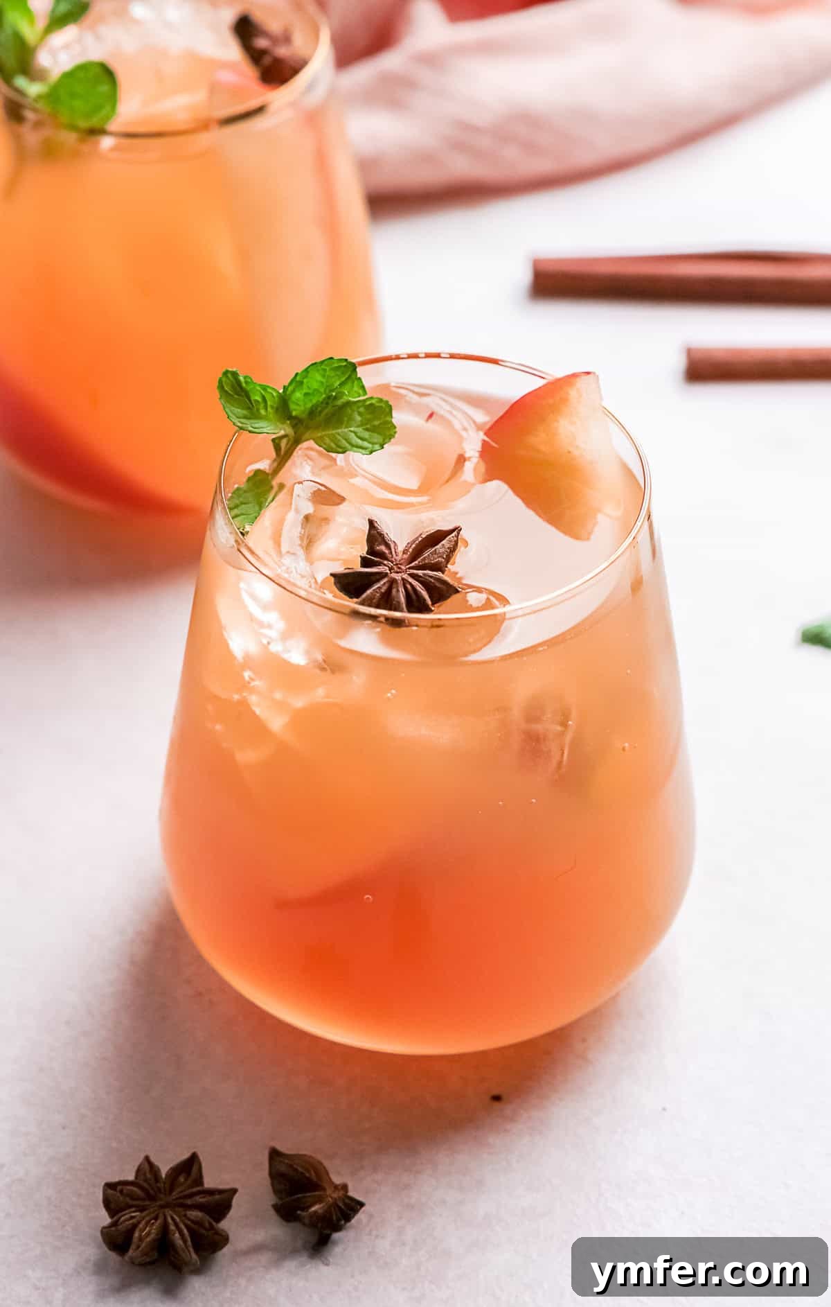 An inviting Apple Cider Mojito in a cocktail glass, garnished with a lime wheel and fresh mint leaves. The glass sits on a wooden surface, evoking a cozy fall atmosphere.