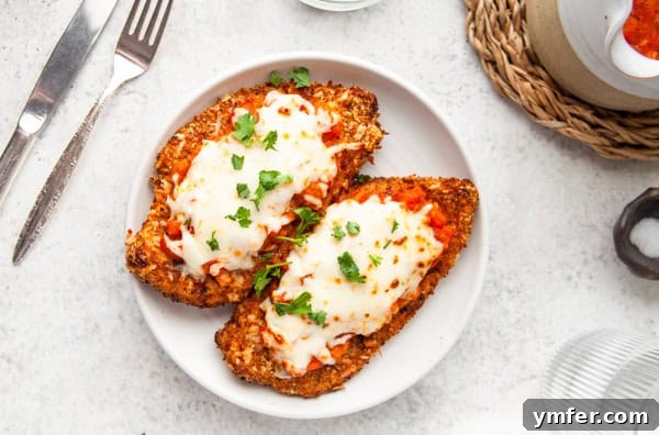 Crispy Air Fryer Chicken Parmesan 6 A perfectly cooked Air Fryer Chicken Parmesan serving on a white plate, showcasing its golden crust and melted cheese.