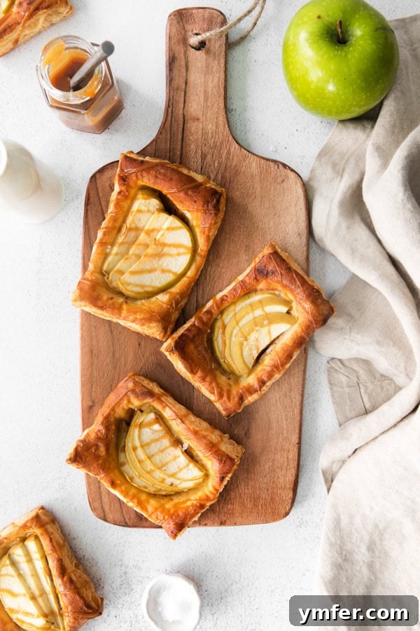 Gooey Apple Caramel Pastry 2 A beautifully baked caramel apple danish, glistening with caramel drizzle, resting on a rustic cutting board. Perfect for breakfast or dessert.