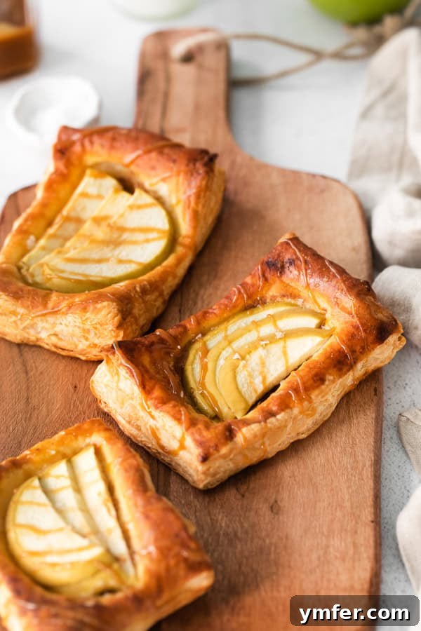 Gooey Apple Caramel Pastry 4 A close-up view of a freshly baked apple danish, expertly drizzled with rich, golden caramel sauce, highlighting its texture and inviting appeal.
