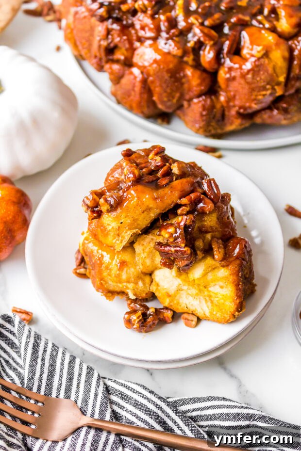 A slice of pumpkin monkey bread on a white plate, showing the gooey caramel and internal pumpkin filling.