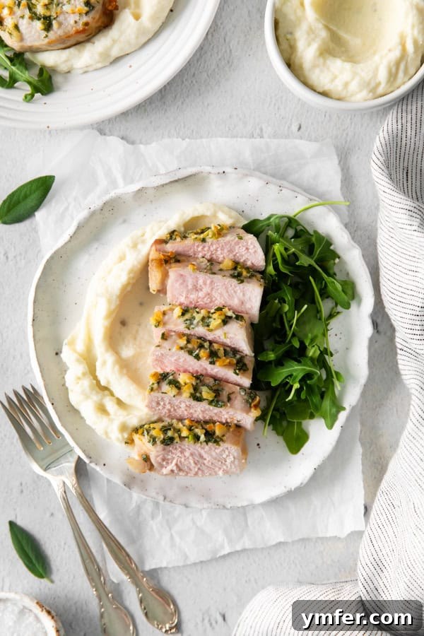 Perfect Air Fryer Pork Chops 2 Air Fryer Pork Chops served on a plate with mashed potatoes and salad.