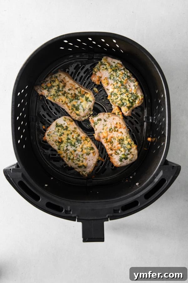 Perfect Air Fryer Pork Chops 4 Air Fryer Pork Chops in the air fryer basket.