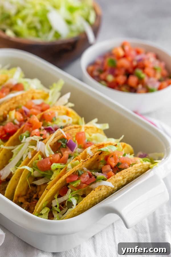 Crispy Baked Beef Tacos 4 Crispy baked ground beef tacos generously topped with fresh shredded lettuce and diced tomatoes.