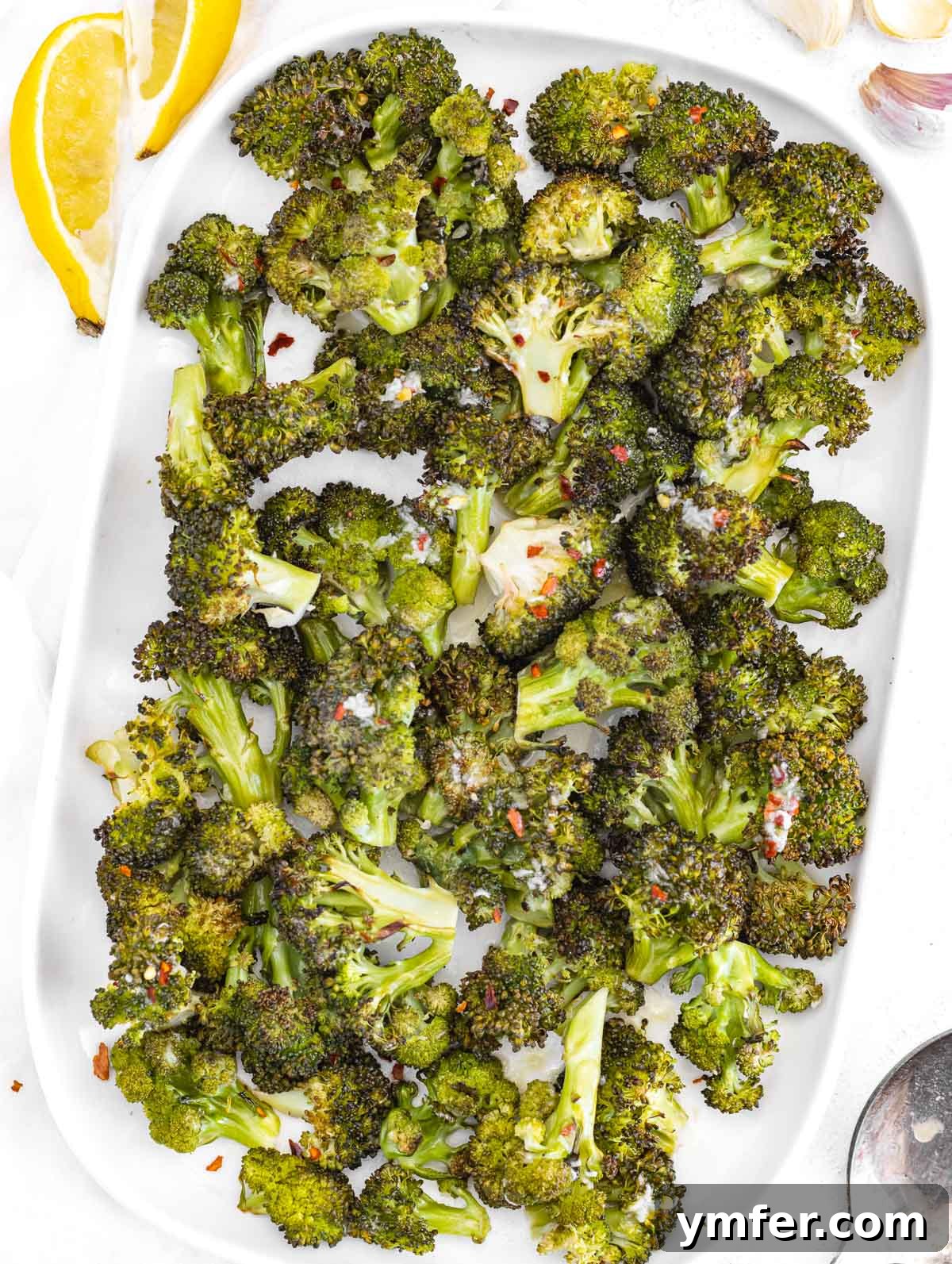 Roasted broccoli on a white platter, ready to serve