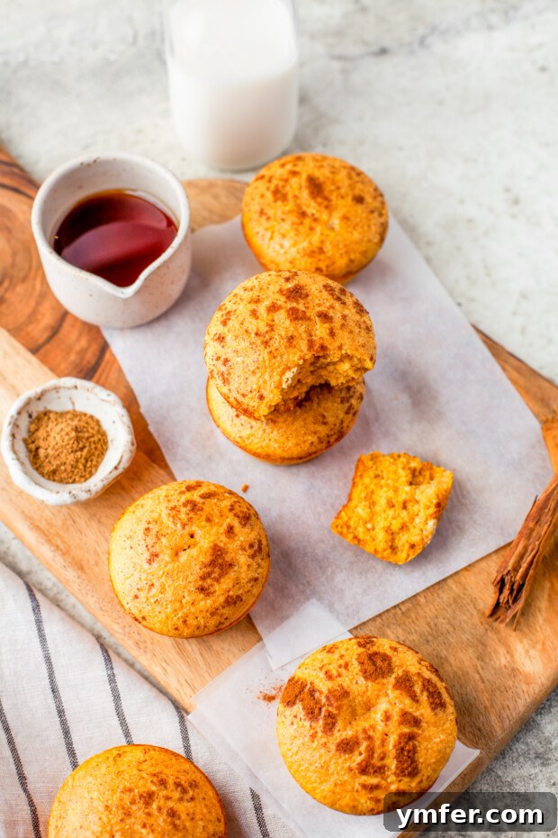 Golden Spiced Pumpkin Cornbread Muffins 2 Delicious Sweet Pumpkin Cornbread Muffins arranged beautifully on a rustic wooden board, ready to be enjoyed.
