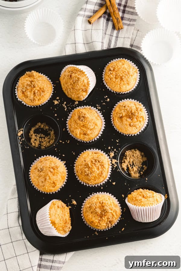 Spiced Sweet Potato Muffins 2 Golden brown sweet potato muffins cooling in a muffin tin, ready to be enjoyed.