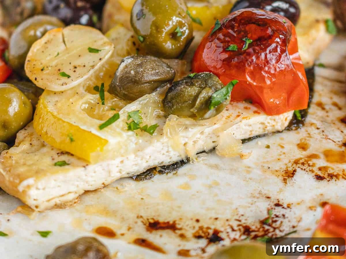 The Vegan Catch 6 vegan fish cut in half with tomatoes and lemon