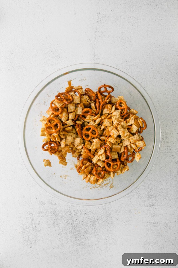Autumn Snack Crunch 5 Chex cereal and pretzels generously coated with the brown sugar mixture, ready for baking.