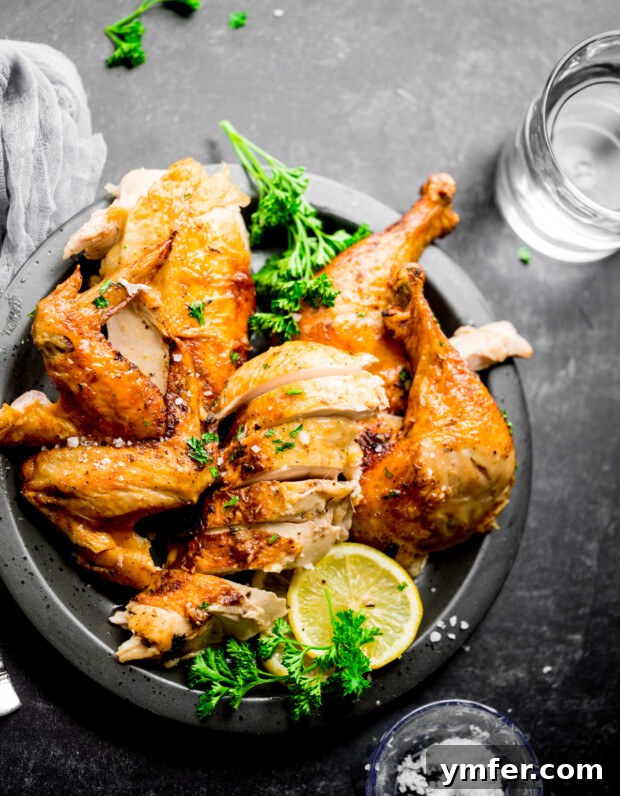 Crispy Air Fryer Whole Chicken 7 Air Fryer Whole Chicken sliced on a plate.