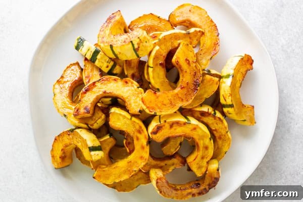 Maple Cinnamon Delicata Jewels 6 Cinnamon Maple Roasted Delicata Squash on a white serving plate, garnished with fresh herbs.