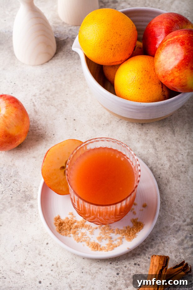 Instant Pot Spiced Apple Cider 6 A glass of Instant Pot Apple Cider sitting on a wooden table.