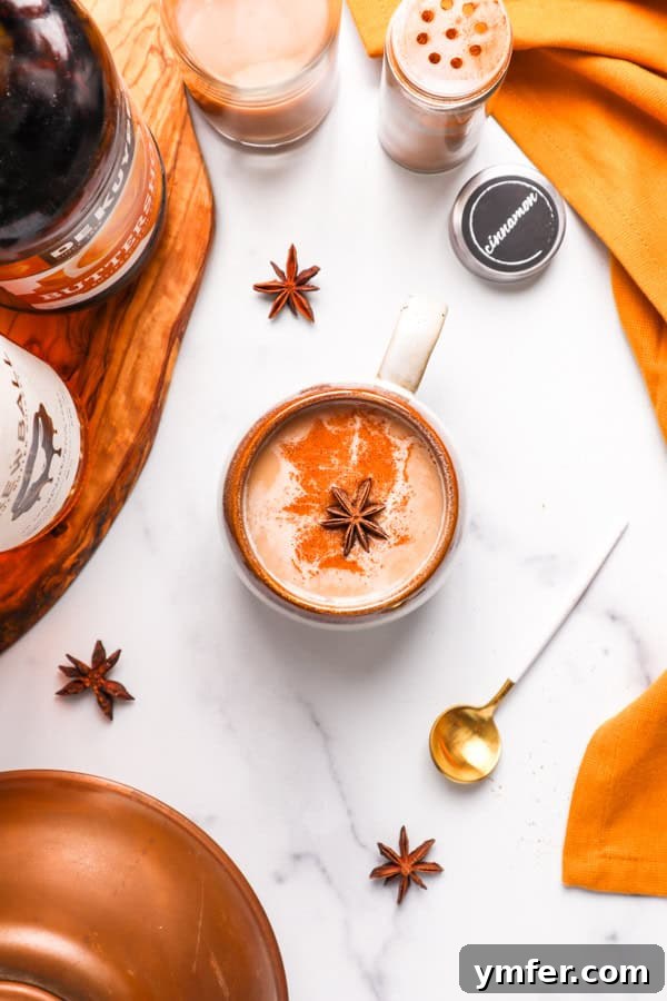 A Skrewball Chai Tea Latte served in a mug, resting on an elegant marble table with a decorative stirrer.