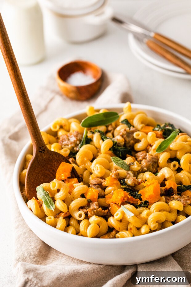 Autumn Butternut Squash Sausage Pasta 7 A serving bowl filled with Butternut Squash Sausage Pasta, showing the creamy sauce and vibrant ingredients.