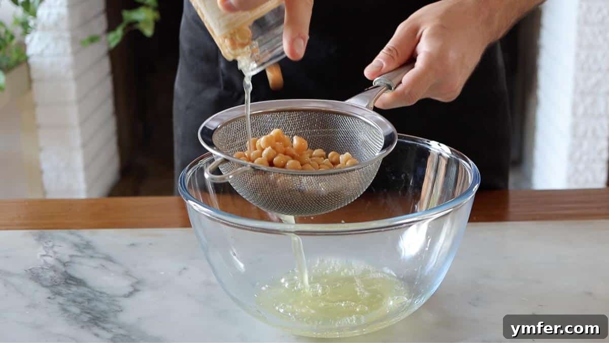 Decadent Chocolate Brownie Cake 9 Straining aquafaba (chickpea water) into a bowl, preparing for its use as an egg replacement