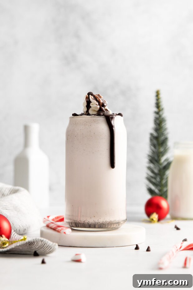 Candy Cane Crunch Milkshake 2 Peppermint Bark Milkshake in a glass with chocolate dripping down the side of the glass.
