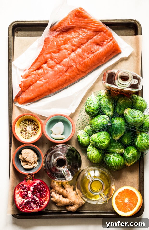 Simple Sheet Pan Marinated Salmon Dinner 3 Essential ingredients for Marinated Sheet Pan Salmon, including fresh salmon, Brussels sprouts, and marinade components, laid out on a kitchen table.