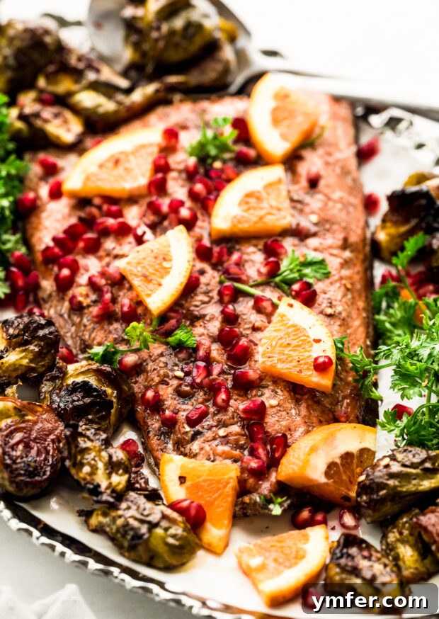 Simple Sheet Pan Marinated Salmon Dinner 6 Cooked Marinated Sheet Pan Salmon on a platter, beautifully garnished with fresh, ruby-red pomegranate seeds.