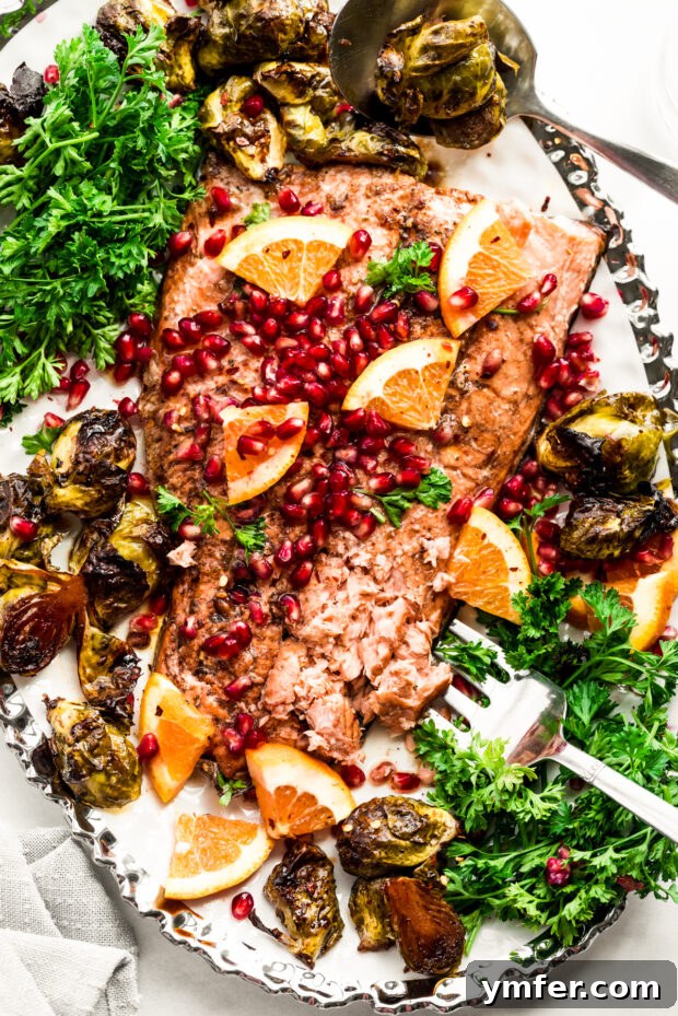 Simple Sheet Pan Marinated Salmon Dinner 7 A serving of Marinated Sheet Pan Salmon and Brussels sprouts on a plate, with a serving fork, ready to be enjoyed.