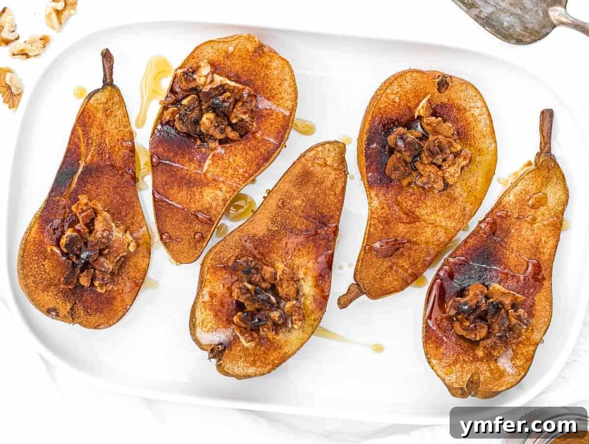 Baked pears with nuts and syrup on a elegant serving platter.