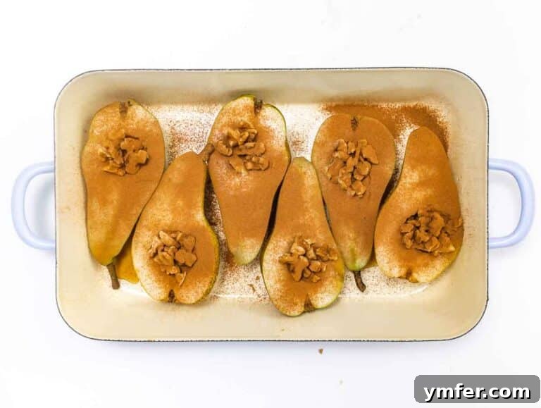 Pear halves filled with walnuts, drizzled with maple syrup, and sprinkled with cinnamon.