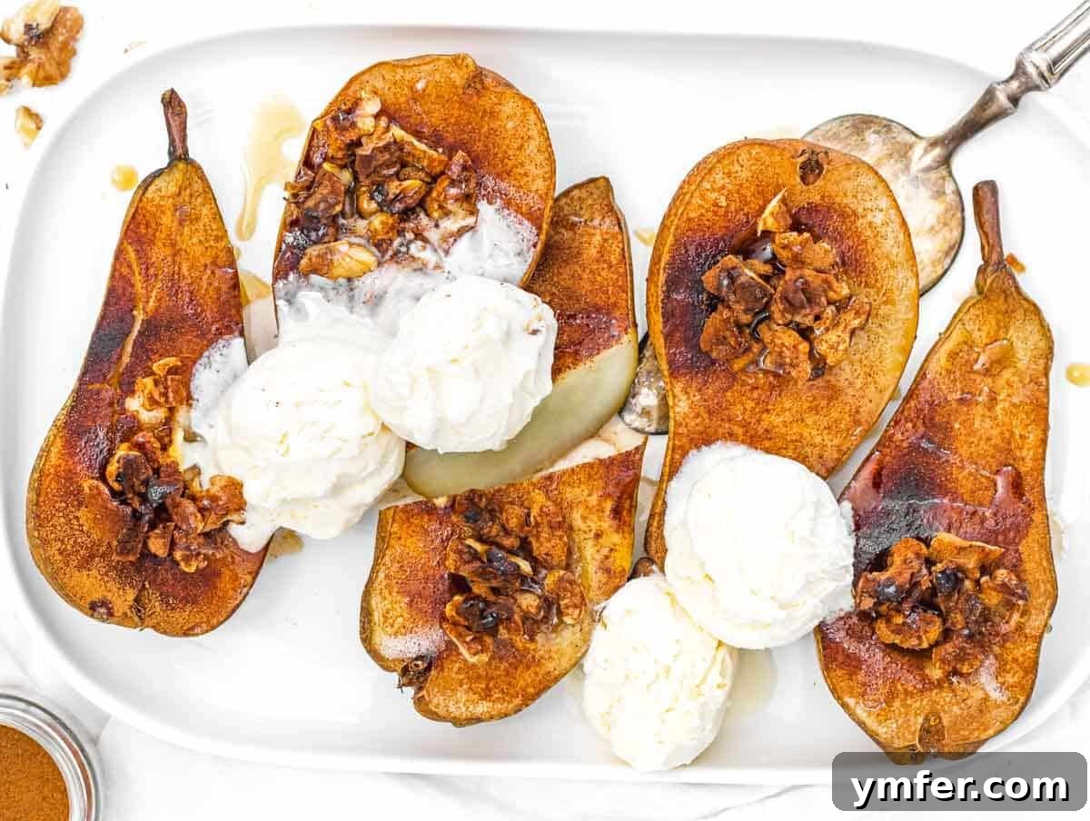 A dish of baked pears served with a scoop of vanilla ice cream, garnished with nuts.