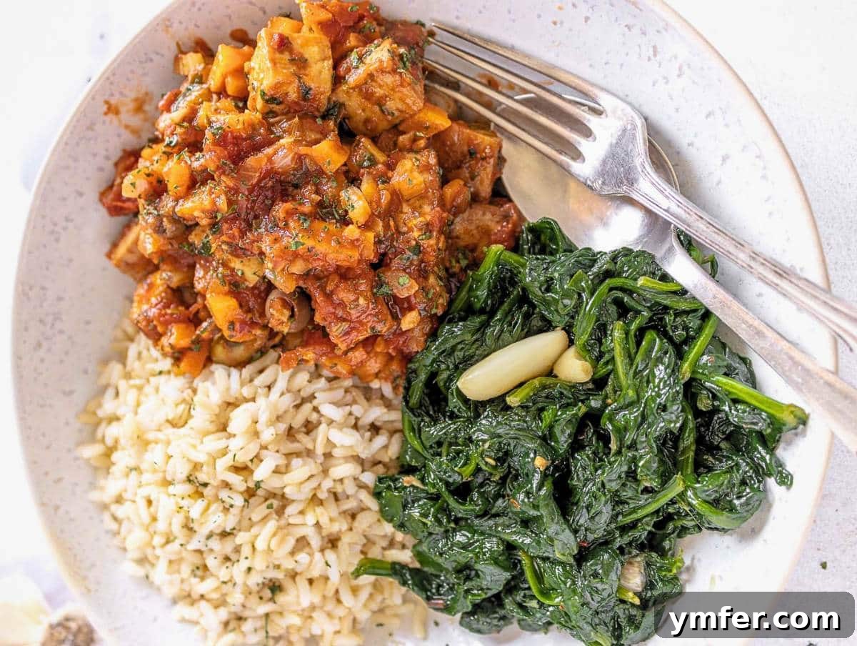 The Forager's Tofu Cacciatore 4 A serving of vegetarian cacciatore in a white bowl, accompanied by sautéed kale and rice, garnished with fresh herbs.