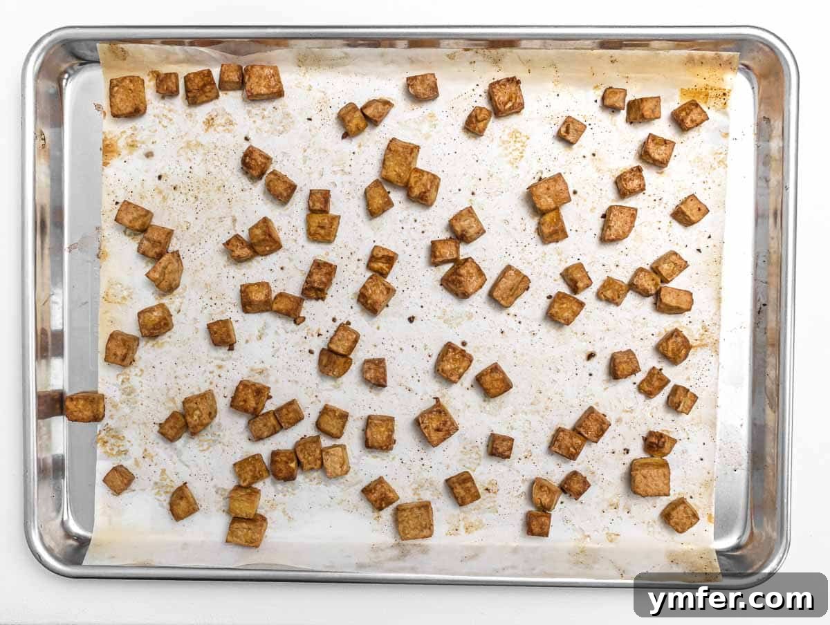 The Forager's Tofu Cacciatore 9 Baked tofu cubes, golden brown and slightly crispy, arranged on a baking sheet.