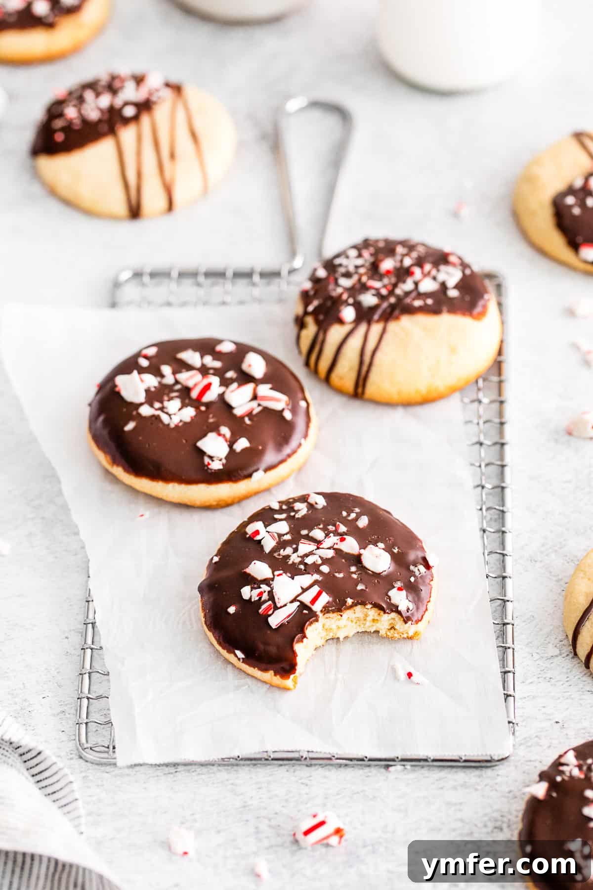 Cool Mint Chocolate Shortbread Delights 5 A plate of Peppermint Bark Shortbread Cookies, one with a bite taken out, showcasing its delicious layers.