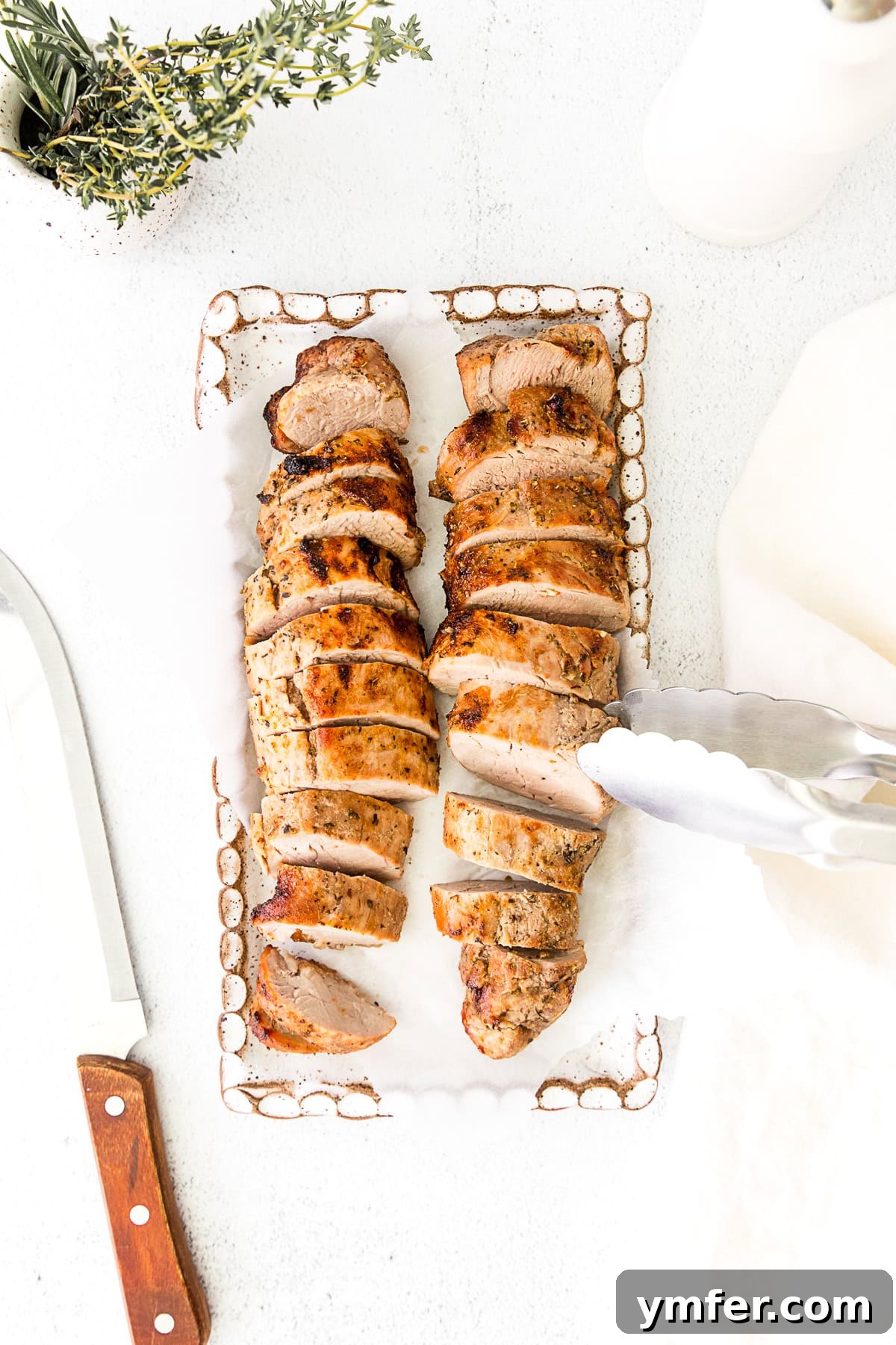 Perfect Air Fryer Pork Tenderloin 6 Air Fryer Pork Tenderloin on a platter, perfectly sliced to reveal its juicy interior.