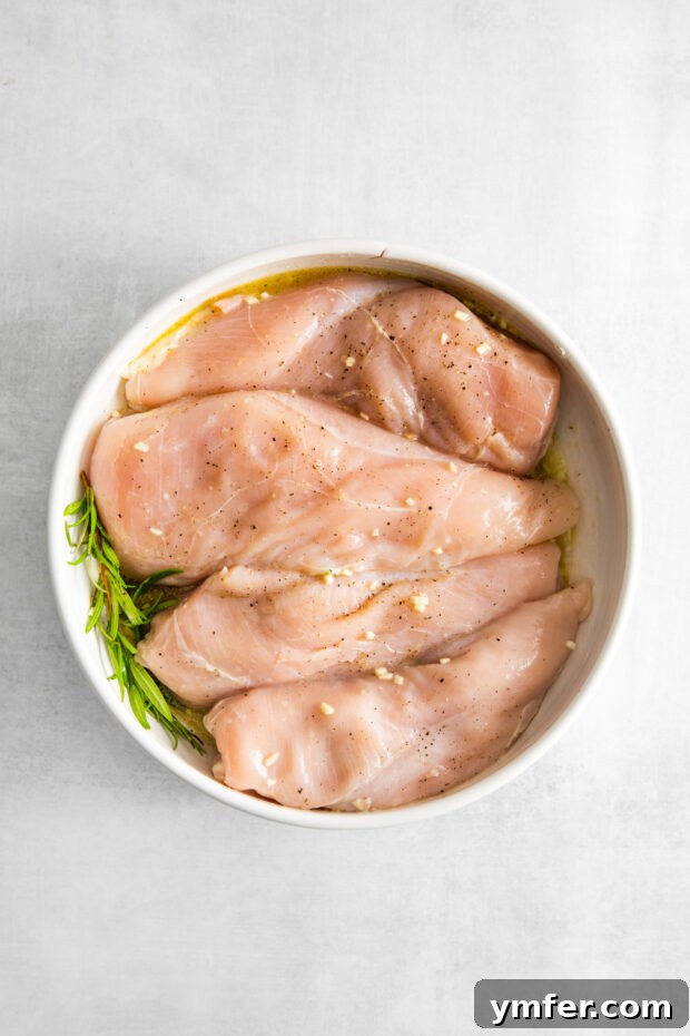 Crispy Zesty Air Fryer Lemon Chicken 4 Air Fryer Lemon Chicken marinating in a bowl.