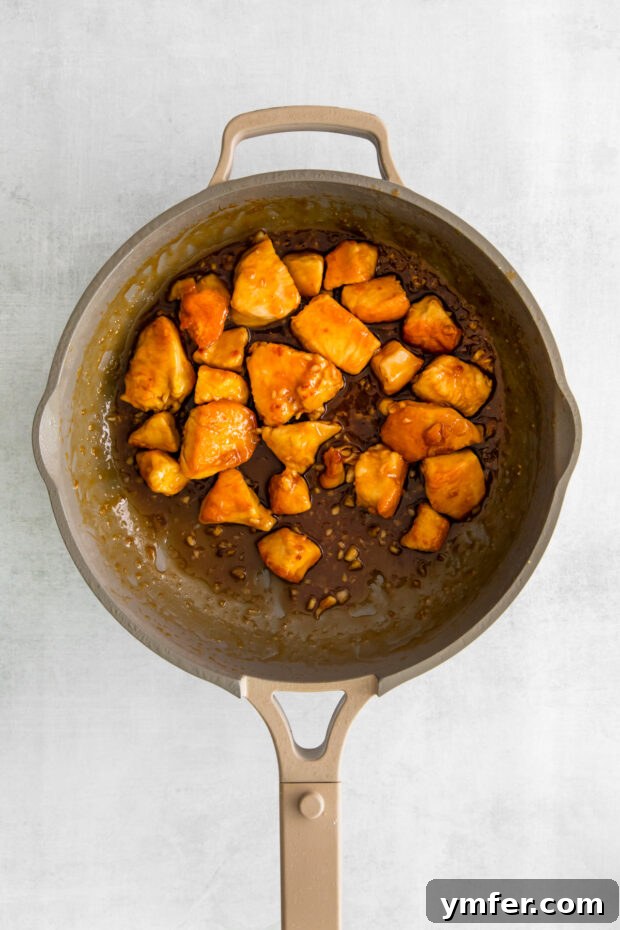 Sticky Honey Garlic Chicken Bowls 6 Crispy chicken coated in a rich honey garlic sauce, glistening in the pan.