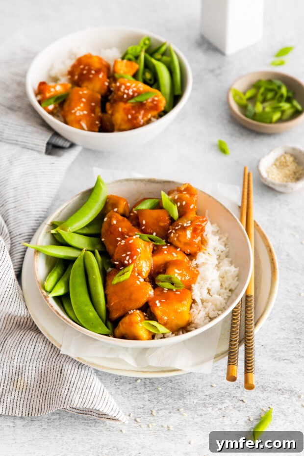 Sticky Honey Garlic Chicken Bowls 9 Honey Garlic Chicken Bowls served with a sprinkle of sesame seeds, highlighting the delicious glaze.