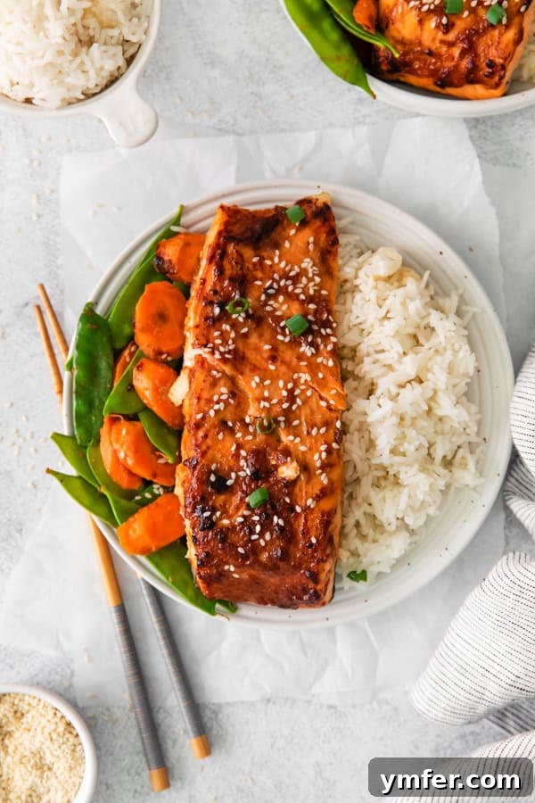 Air Fried Miso-Glazed Salmon 2 Air Fryer Miso Salmon on a plate with rice, garnished with fresh herbs.