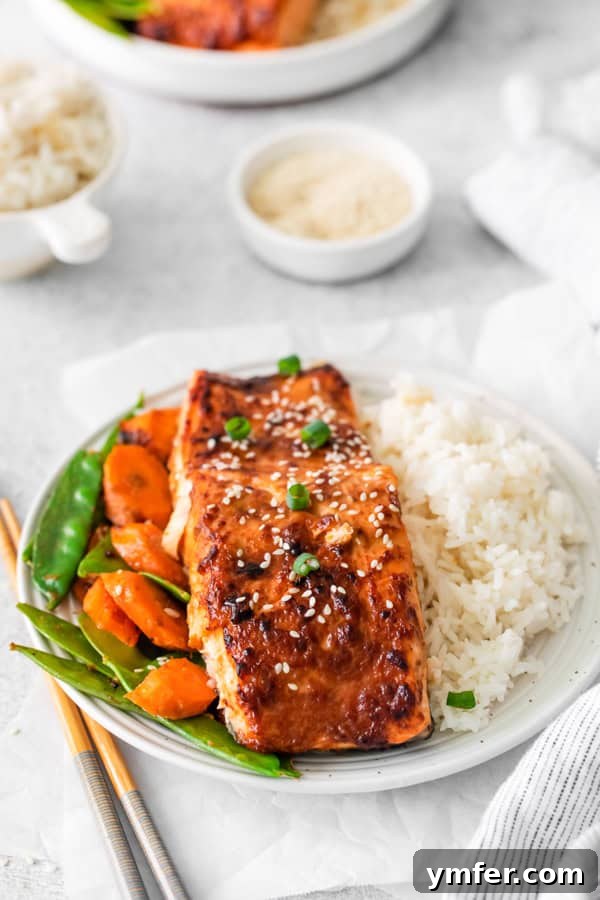 Air Fried Miso-Glazed Salmon 6 Air Fryer Miso Salmon on a plate, sprinkled with white and black sesame seeds for garnish.